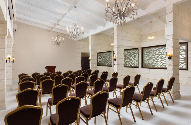 Sala de conferencias con sillas doradas y chandeliers elegantes en All Seasons Resort