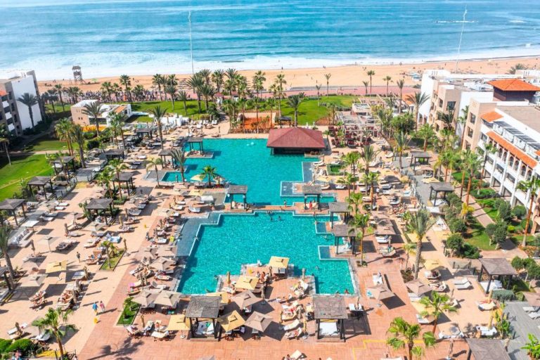 Piscinas exteriores con tumbonas y palmeras del Hotel Riu Palace Tikida Agadir frente a la playa