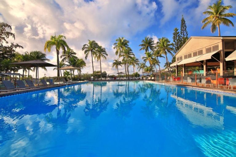 Amplia piscina exterior con palmeras tropicales del La Creole Beach Hotel & Spa en Guadalupe