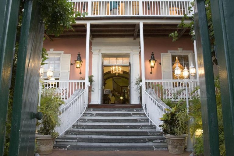 Entrada principal del Graycliff Hotel con escalinata de piedra, faroles y fachada colonial rosa
