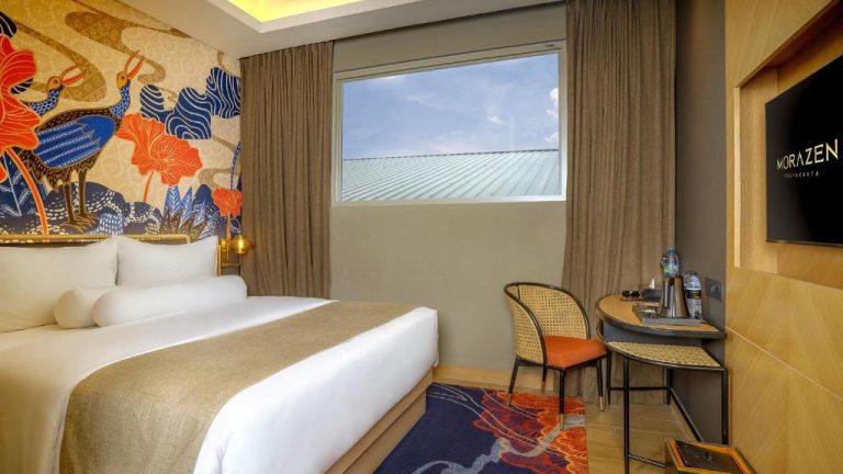 Habitación doble con mural batik tradicional y escritorio en el hotel Morazen Yogyakarta