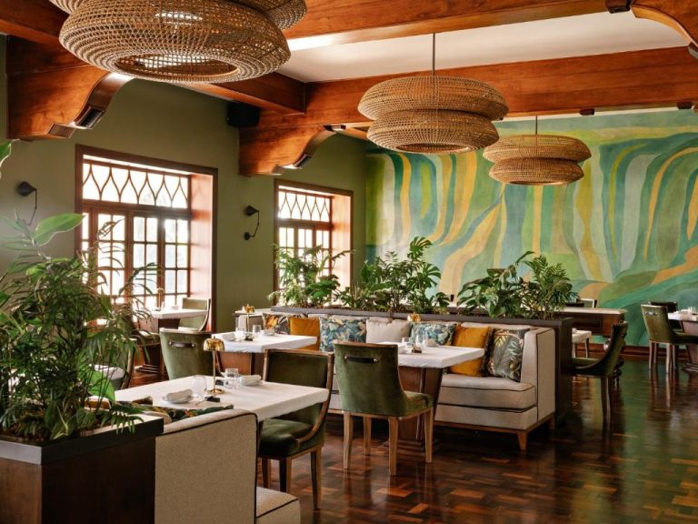 Elegante restaurante interior del Hotel das Cataratas Belmond con decoración tropical y murales en Iguazú