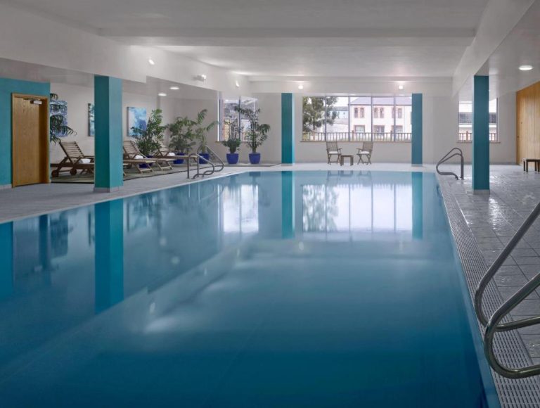 Piscina interior climatizada del Radisson Blu Hotel Athlone con tumbonas y plantas decorativas