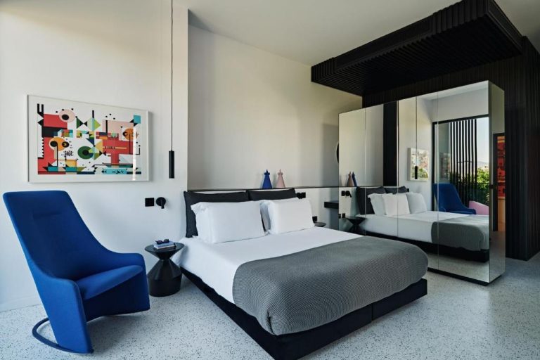 Habitación de diseño moderno con cama doble y silla azul en MAP Boutique Hotel