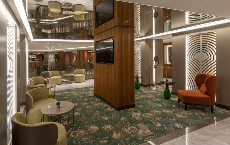 Elegante lobby lounge del DoubleTree by Hilton Istanbul Sirkeci con sillones y alfombra decorativa