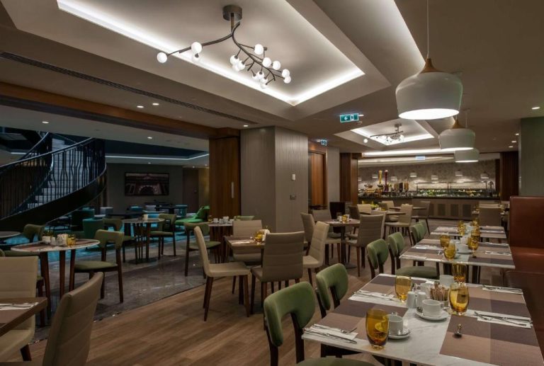 Restaurante elegante con mesas preparadas y decoración moderna en DoubleTree by Hilton Istanbul Sirkeci