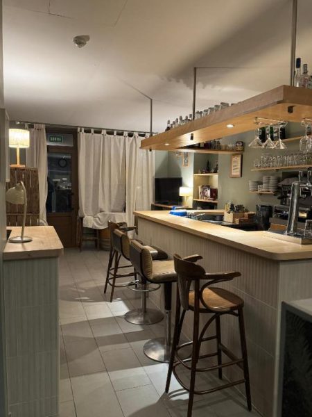 Bar interior elegante con taburetes de madera y mostrador iluminado en el Hôtel Fleur des Alpes