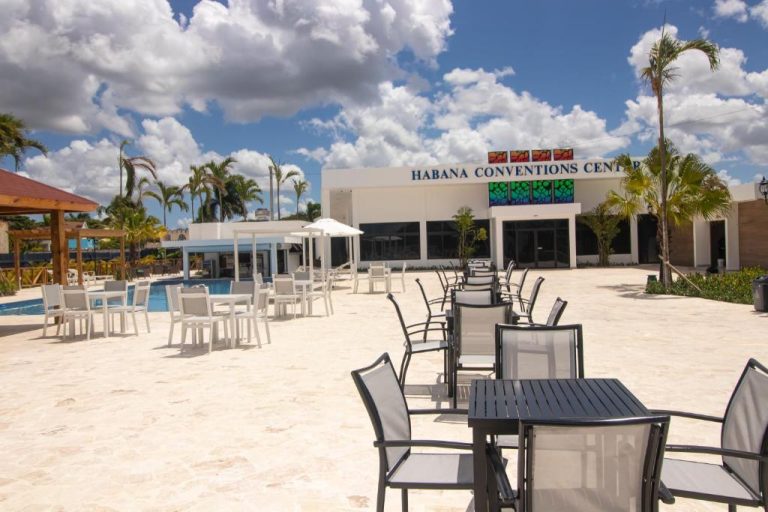 Terraza exterior con mesas y sillas junto a la piscina del Habana Hotel Y Restaurante y centro de convenciones