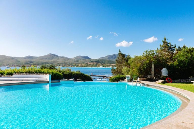 Piscina exterior con vistas al mar y montañas del Hotel Palumbalza Porto Rotondo en Cerdeña