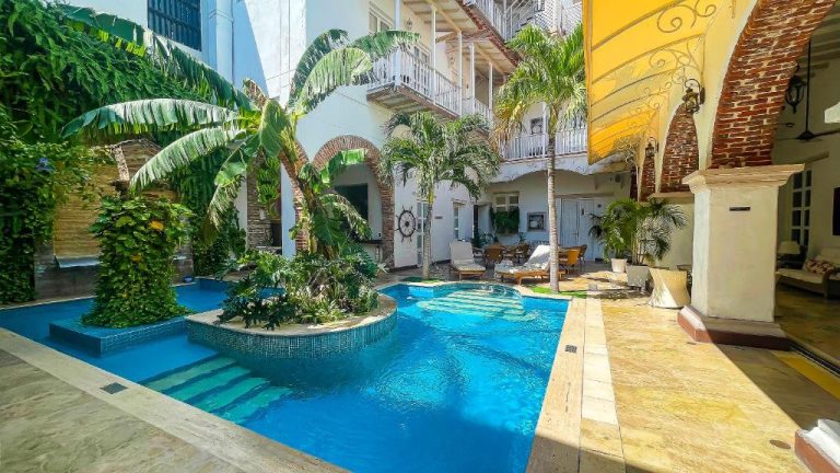 Piscina interior con palmeras y jardín tropical en el patio colonial del Hotel Boutique Don Pepe