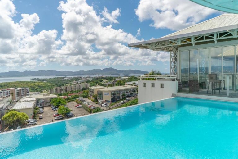 Piscina infinita con vistas panorámicas a la ciudad y bahía en Karibea La Valmenière Hôtel