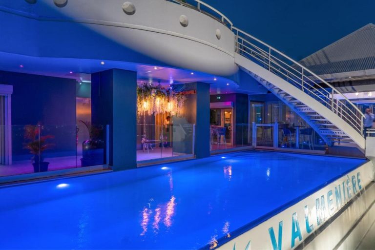 Piscina interior iluminada con luces azules del Karibea La Valmenière Hôtel vista nocturna