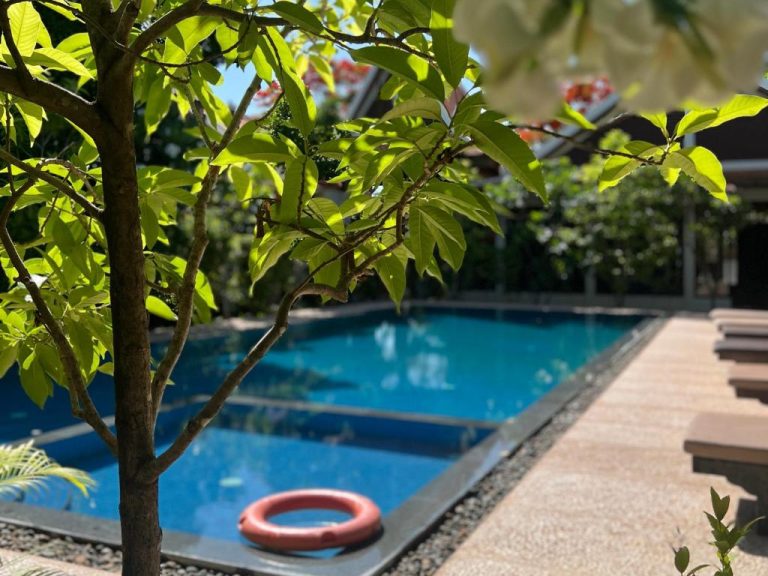 Piscina privada rodeada de vegetación tropical en Villa Phum Khnar con flotador de seguridad