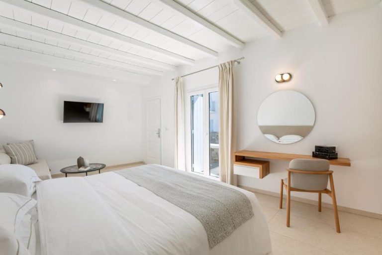 Habitación doble con cama king, escritorio de madera y espejo redondo en Paradise View Hotel
