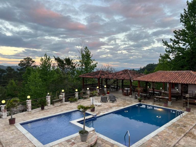 Piscina exterior con terraza y mirador panorámico del Hotel y Cabañas ROS entre el bosque