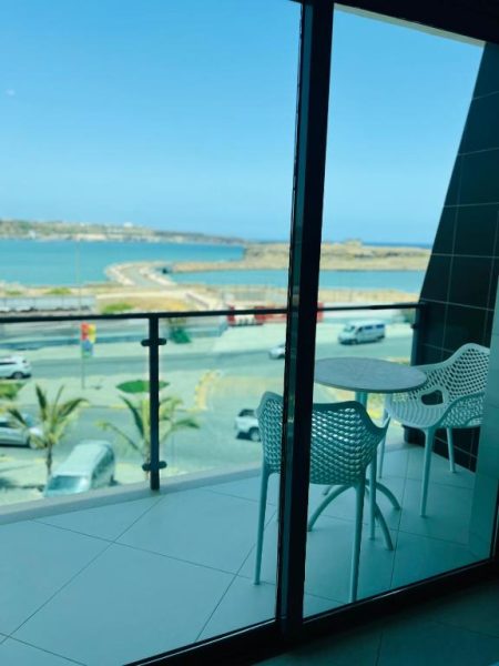 Balcón con mesa y sillas blancas del Beramar Hotel con vistas al mar y al puerto