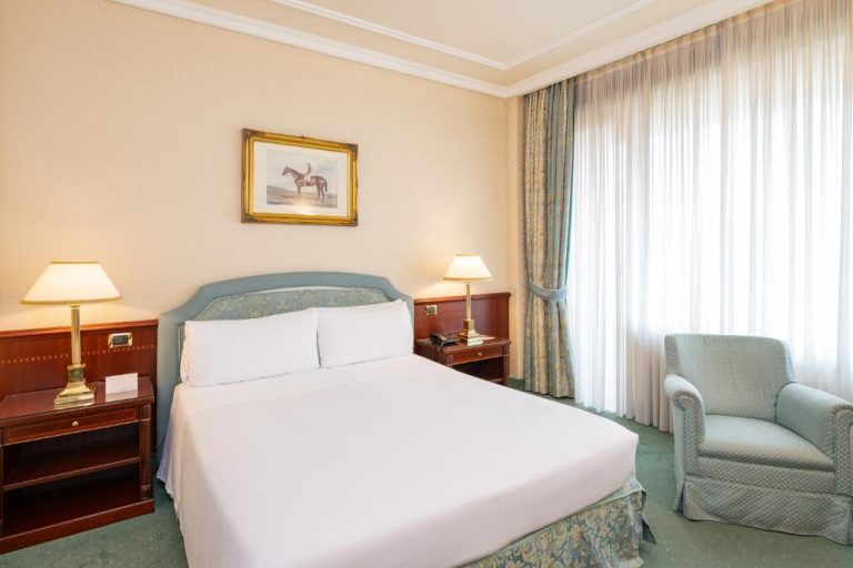 Habitación doble clásica con cama matrimonial y decoración elegante en el Royal Hotel Carlton