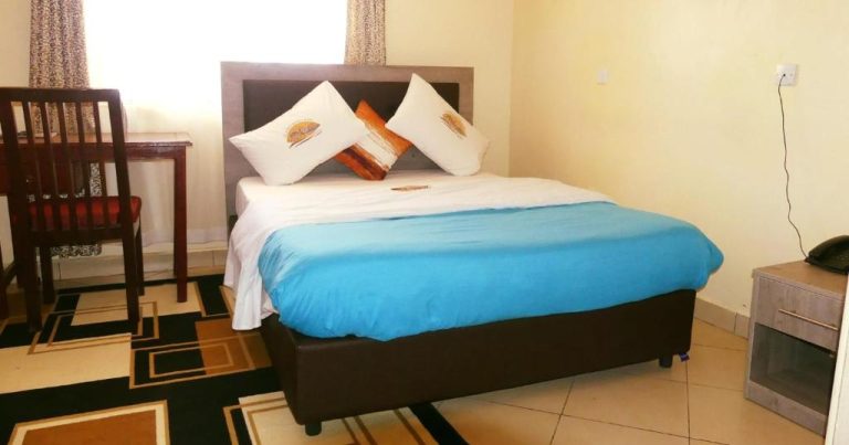 Habitación doble con cama matrimonial y ropa de cama azul en Elboran Resort and Spa