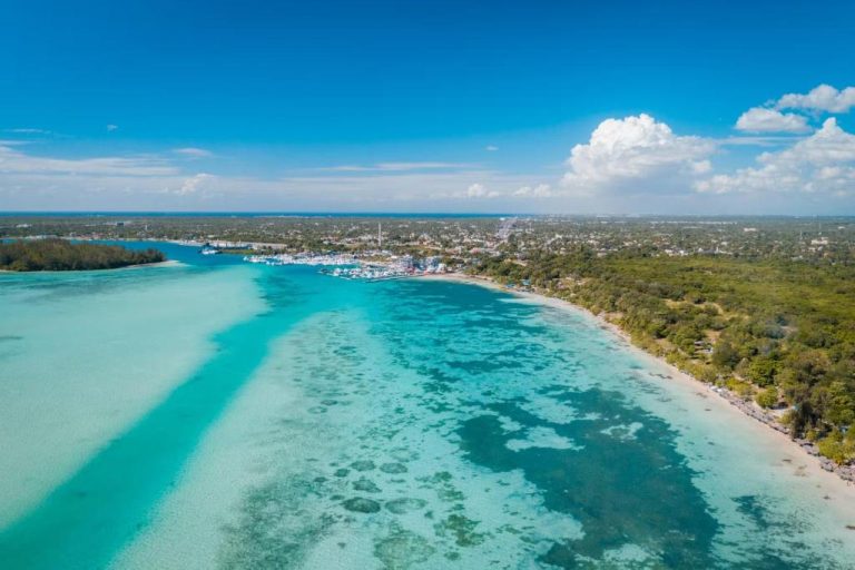 Vista aérea de la playa y aguas turquesas junto al Hotel Hannabi con marina y vegetación tropical