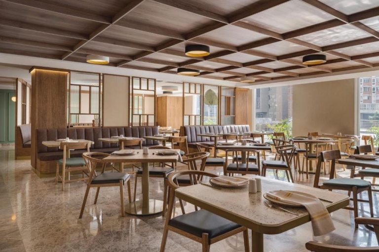 Restaurante elegante con mesas de madera y amplia iluminación natural en Four Points by Sheraton Tequendama Bogotá