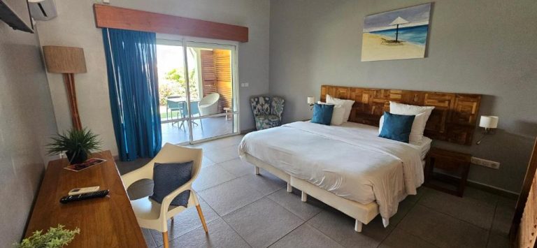 Habitación doble con cama king, cabecero de madera y terraza exterior en Hôtel Le Soleil Levant