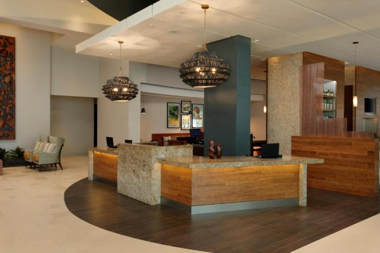 Recepción moderna del Hyatt Place Manatí con mostrador de granito y lámparas decorativas colgantes