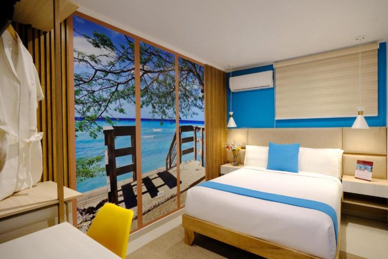 Habitación doble con mural de playa tropical y cama king size en el Victoria City Hotel