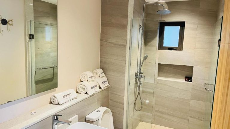 Baño moderno con ducha de lluvia y toallas del hotel Minissy Suites