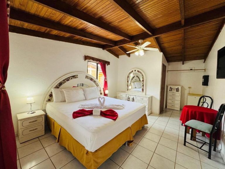 Habitación doble con cama matrimonial y techo de madera en Hotel Villas del Valle