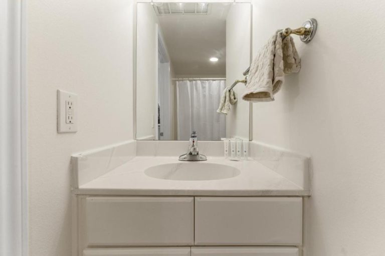 Baño moderno con lavabo de mármol blanco y espejo en Shores of Panama Beachfront