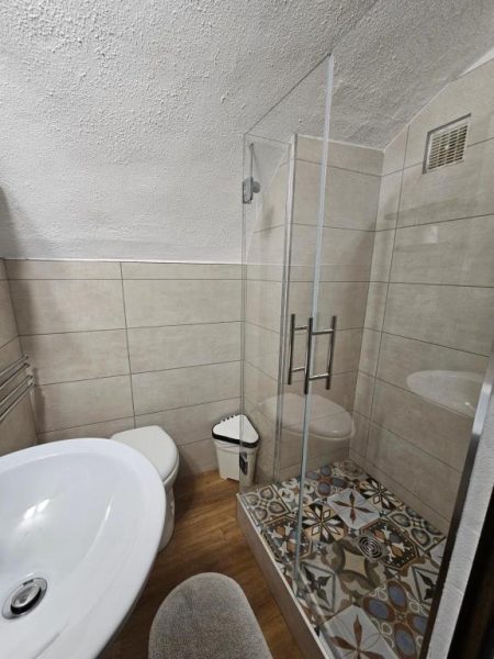 Baño completo con ducha de cristal y suelo de mosaico en Auberge Saint Martin