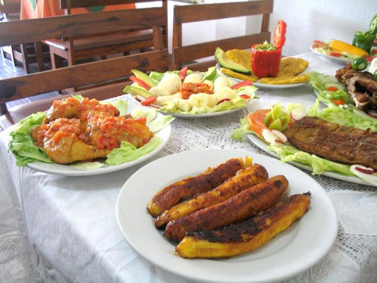 Variedad de platos típicos con pollo, pescado, plátanos fritos y ensaladas servidos en Hotel Casa Vieja
