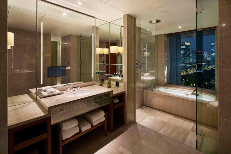 Baño de lujo con bañera y vistas nocturnas a Tokio en el Palace Hotel Tokyo