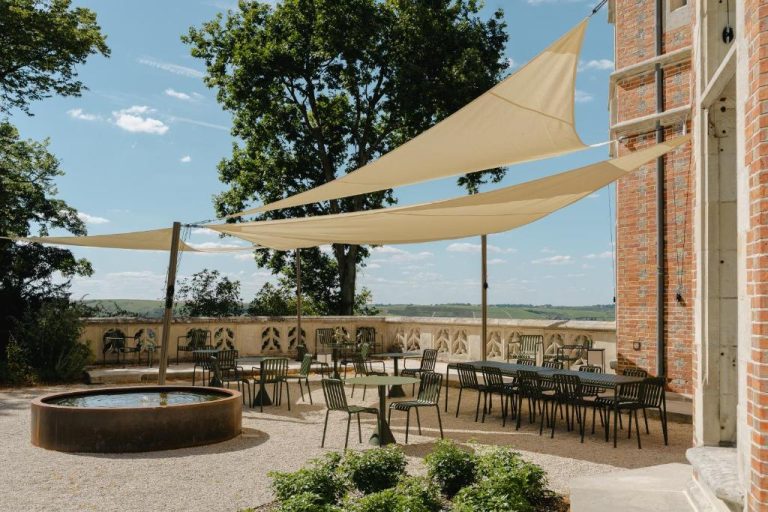 Terraza exterior con mesas y velas de sombra en Les Hauts de Sancerre con vistas al viñedo
