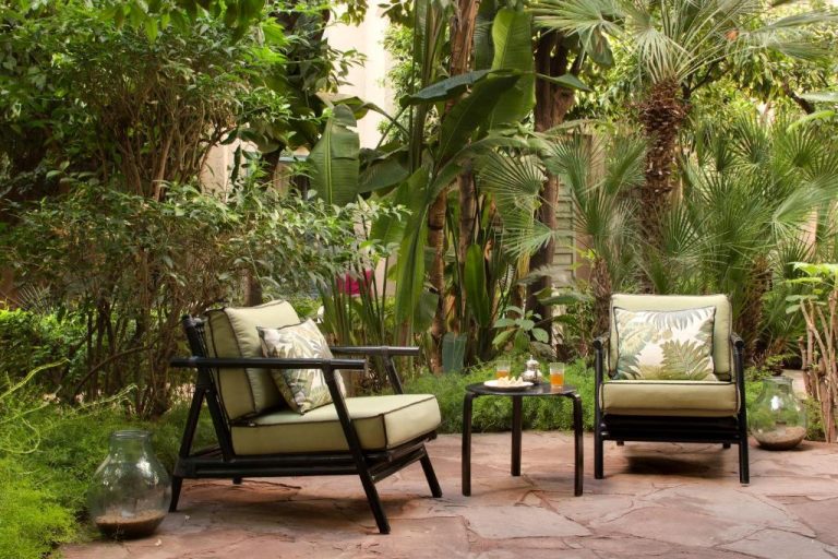 Terraza con sillones de jardín y vegetación tropical en Les Jardins de La Médina Marrakech