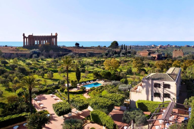 Vista aérea de la piscina exterior del Villa Athena Resort con el Templo de la Concordia de Agrigento al fondo