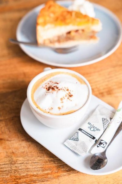 Cappuccino con espuma y tarta de manzana casera servidos en Landhuis Daniel Plantation House
