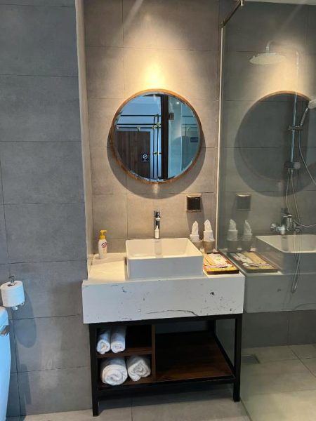 Baño moderno con lavabo sobre encimera de mármol y ducha en Hanna Seaview Stella The Arena Resort