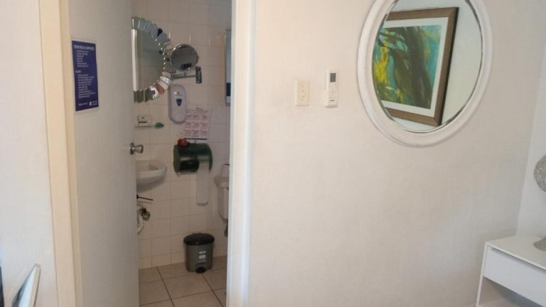Baño completo con espejo redondo, lavabo y aseo del Hotel Chez Lilly