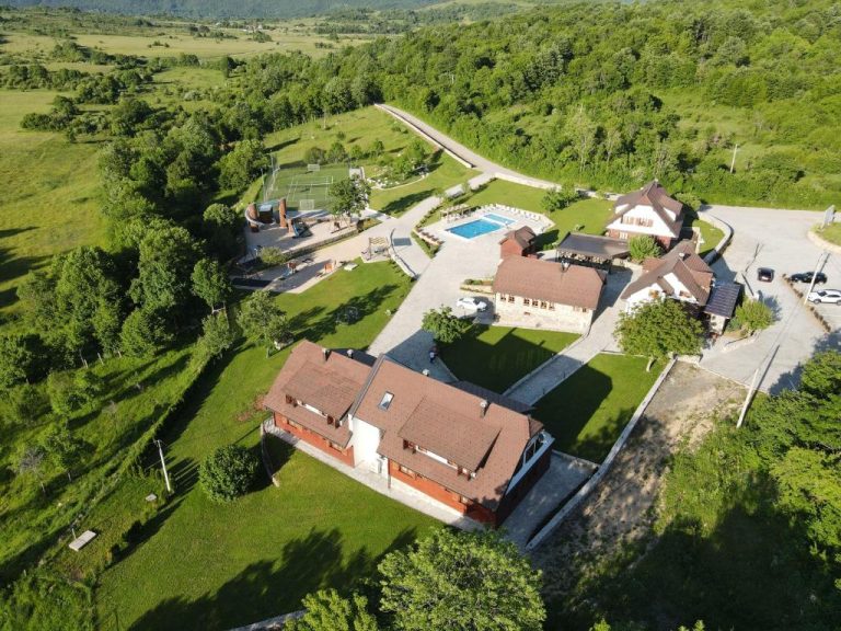 Vista aérea del complejo Plitvice Village con piscina exterior, pistas de tenis y cabañas rodeadas de naturaleza