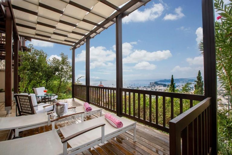 Terraza privada con tumbonas y vistas al mar y ciudad en The Marmara Bodrum Adult Only