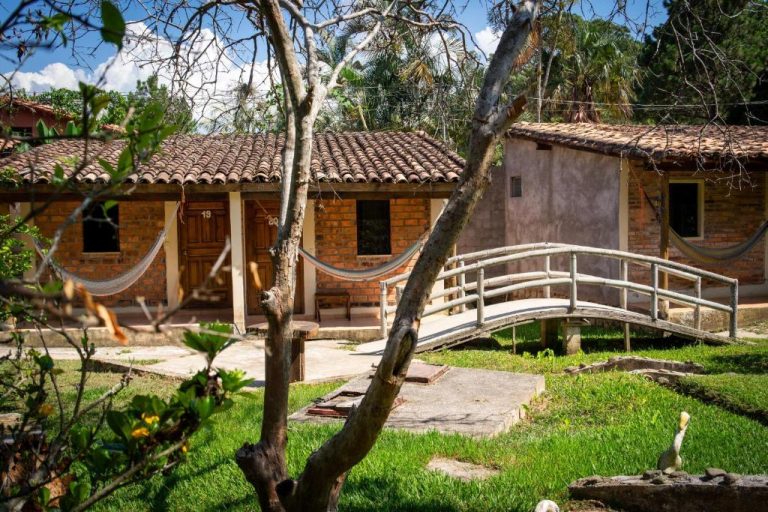 Cabañas de ladrillo con jardín y puente decorativo en Hotel Villas del Valle