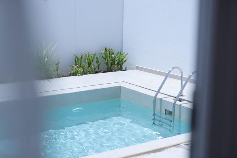 Piscina privada de agua cristalina con escalera de acero en Palms Residence Inn دار النخيل