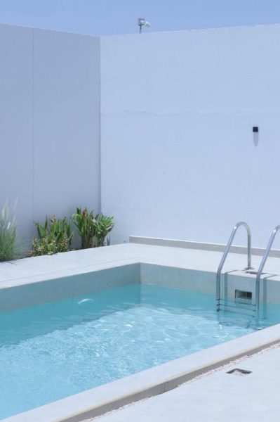Piscina privada exterior de agua cristalina en Palms Residence Inn دار النخيل con escalera de acero