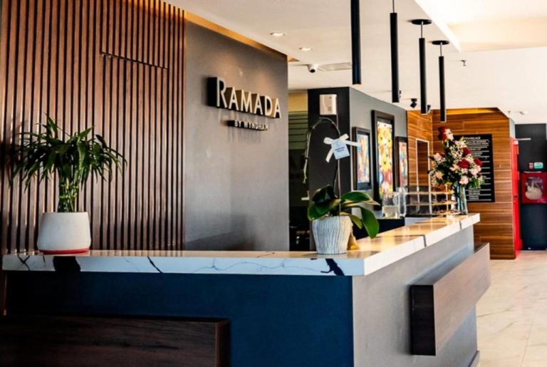 Recepción moderna del Ramada Suites by Wyndham Asunción Aeropuerto con mostrador de mármol y decoración elegante