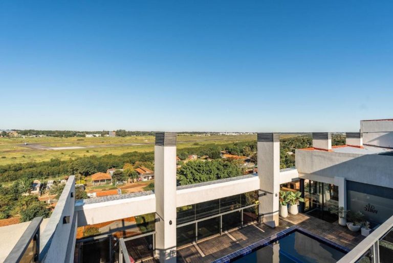 Terraza con piscina y vistas panorámicas al aeropuerto desde el Ramada Suites by Wyndham Asunción