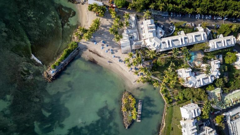 Vista aérea del Canella Beach Hotel con playa privada, palmeras y aguas turquesas en Guadalupe