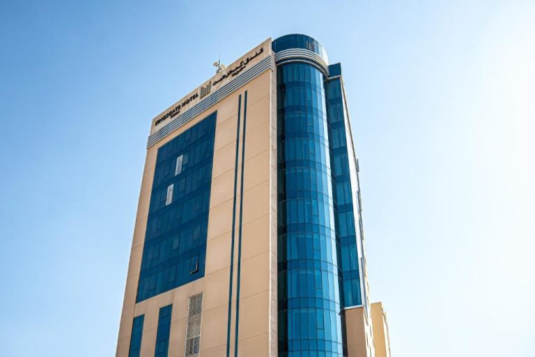 Fachada exterior del Kingsgate Hotel Doha by Millennium Hotels con torre de cristal azul