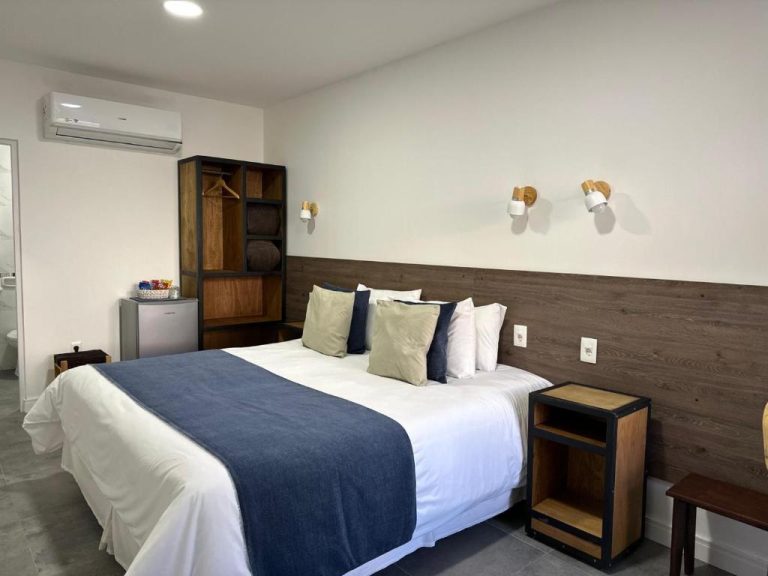 Habitación doble con cama king size y cabecero de madera en Hotel FK Paso de los Toros Boutique