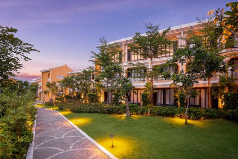 Jardines exteriores iluminados al atardecer del Moire Hoi An Vignette Collection by IHG en Vietnam
